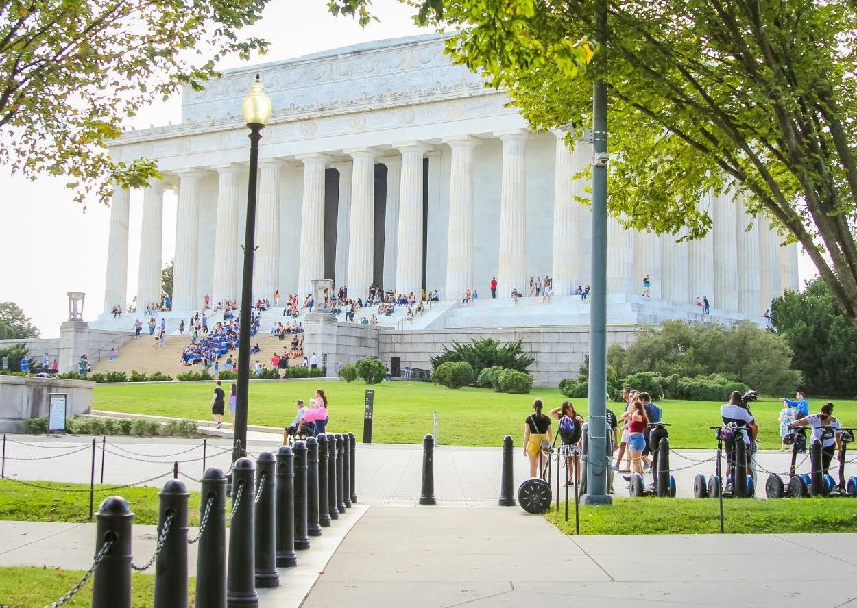 a woman standing on a sidewalk in front of a building
