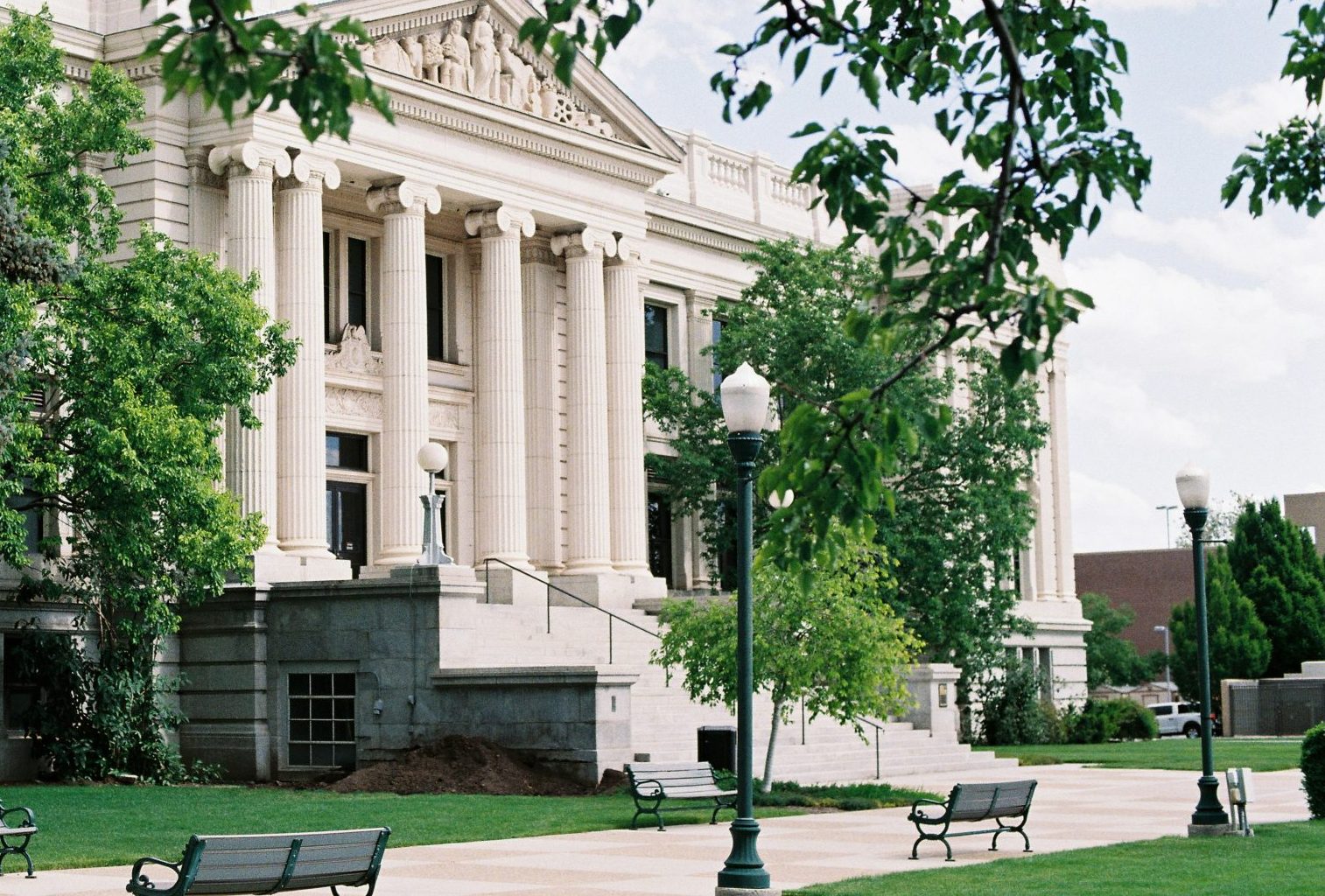 A large building with columns stands in the park.